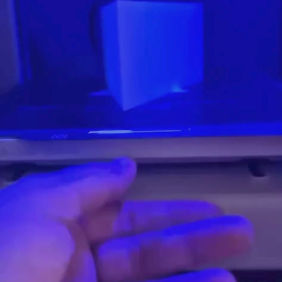 White triangular book stand with an intricate cut-out tree design, displayed on a white surface against a light grey background.