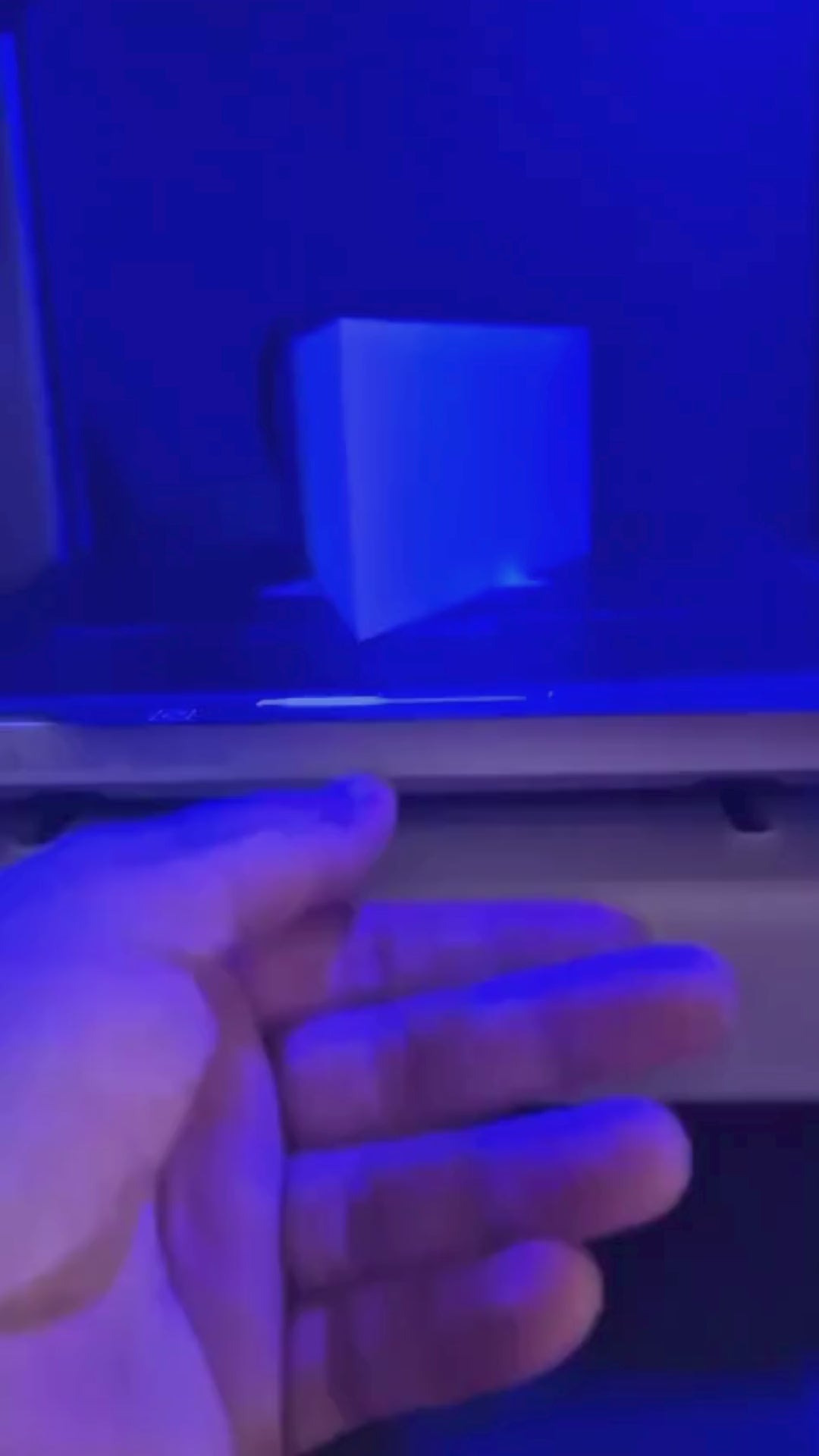 White triangular book stand with an intricate cut-out tree design, displayed on a white surface against a light grey background.