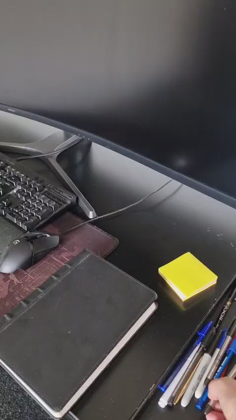Modern black 3-piece desk organizer set including a ribbed pen holder, textured tray with earbuds case, and sticky notes holder with stencil cards on a black desk.